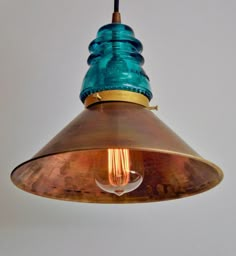 a copper and blue light hanging from a ceiling