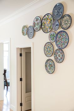 the wall is decorated with many plates on it