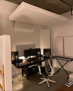 an office with two computers and speakers on the desk