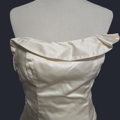 the back of a white dress on a mannequin headdress with an open shoulder