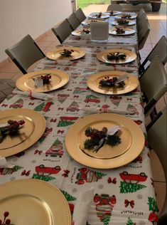 the table is set for christmas dinner with plates and silverware on it, along with other place settings