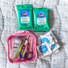 the contents of a travel bag laid out on a bed, including toothpaste, wipes and scissors