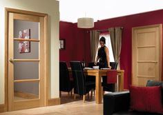 a woman standing at a table in a room with red walls and black leather chairs