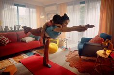 two girls are playing with each other in the living room while one girl is on her back