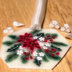 a white and red object on a wooden table with dices around it that have been decorated with flowers