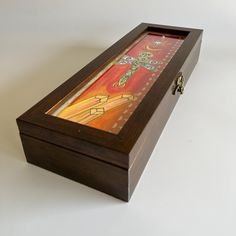 a wooden box with a painting on the front and sides inlayed to it