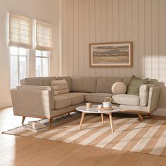 a living room filled with furniture on top of a hard wood floor covered in striped rugs