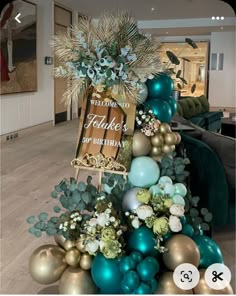 a christmas tree decorated with blue, gold and green ornaments in a living room area