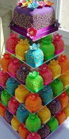 a multi - tiered cake is decorated with brightly colored candies