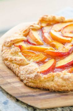 a fresh peach pie on a wooden cutting board