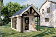 a small white shed sitting on top of a lush green field next to a building