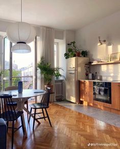 a kitchen and dining room with wood flooring in an apartment type building, overlooking the city