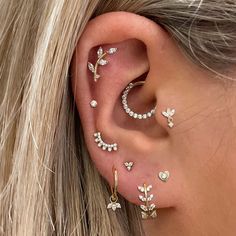 a close up of a person with ear piercings on their ears and behind the ear