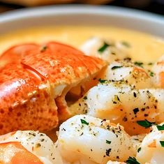 a bowl filled with lobster and grits on top of a table