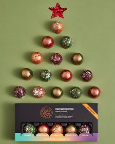 a christmas tree made out of chocolates on top of a green surface with red and gold decorations