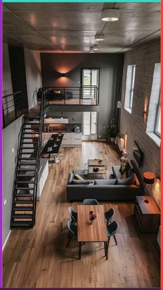 an aerial view of a living room and dining area with stairs leading up to the second floor