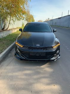 a black car is parked on the side of the road