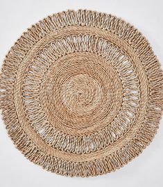 a round woven placemat on a white surface with an oval pattern in the middle