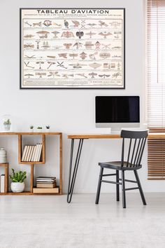 a desk with a computer on top of it next to a chair and bookshelf