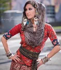 a woman in a red dress is standing with her hands on her hips and wearing jewelry