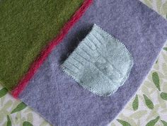 three different colored pieces of felt sitting on top of a table cloth covered in green, purple and pink