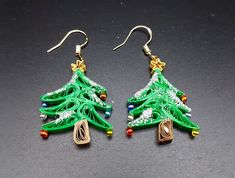 Are you looking for a special gift for someone or yourself? This is exactly what you are looking for. These beautiful hand crafted earrings are made from 1/8" thick quilling paper strips in green, brown and gold  colors. They are attached to hypo-allergenic silver plated earring hooks.  The earrings are coated with clear acrylic sealant to provide sturdiness to the jewelry. But it is not 100% water-proof. Please remove jewelry prior to swimming, bathing, or other water-based activities. In case of water contact, gently dab with a paper towel and allow to dry completely.  Please message me for custom order requests or questions. The rest of my collection is available at  https://breezechicdesigns.etsy.com Handmade Jewelry For Christmas Celebration, Holiday Handmade Earrings For Celebration, Handmade Christmas Celebration Earrings, Handmade Christmas Earrings For Celebration, Handmade Earrings For Holiday Celebrations, Handmade Jewelry For New Year Holiday, Handmade Earrings For Celebrations And Holidays, Handmade Festive Earrings For Christmas, Handmade Jewelry For Christmas Crafting