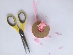 two pairs of scissors are next to a yarn ball and pair of pink crochet hooks