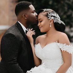 a bride and groom are posing for a photo in their wedding gowns with flowers on the head