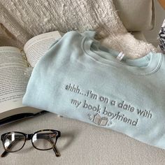 Introducing the "Shhh... I'm on a date with my book boyfriend" Book Boyfriend Sweatshirt, the perfect addition to your pop of color to your outfit and can make you stand out in a crowd. The "Shhh... I'm on a date with my book boyfriend" Book Boyfriend Sweatshirt is a cozy reading sweatshirt, perfect for curling up with your favorite book. The sweatshirt is designed to keep you warm and comfortable while you read, making it an ideal choice for chilly evenings. The sweatshirt is made from organic cotton, which is a more sustainable and eco-friendly choice compared to regular cotton. This means that you can feel good about your purchase while enjoying the comfort and style of this sweatshirt. The minty green color of the sweatshirt is a great way to add a pop of color to your outfit. It can m Book Shirts Aesthetic, Book Lover Sweatshirt, Booktok Sweatshirts, Book Hoodies, Reading Outfits, Book Sweatshirts, Reading Sweatshirt, Boyfriend Sweatshirt, Bookworm Gifts