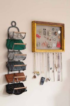 a wall mounted jewelry rack with several pairs of earrings hanging from it's sides