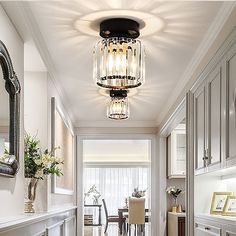 the hallway is decorated in white and features an elegant chandelier