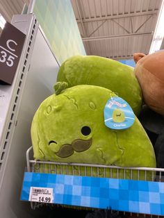 two large stuffed animals sitting on top of each other in a shopping cart at a store