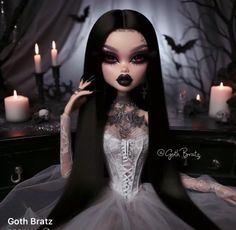 a doll with long black hair and white dress sitting in front of candle lit candles