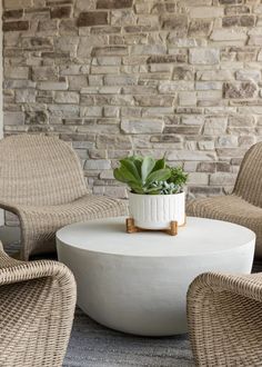 a white table with some chairs and a potted plant sitting on top of it