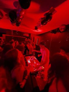 a group of people in a room with red lights