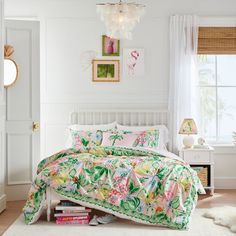 a bedroom with white walls and flooring has a floral comforter set on the bed