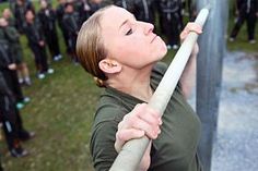 a woman holding a baseball bat in front of a group of people