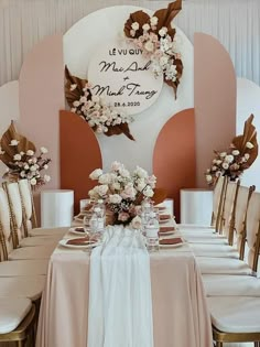 the table is set with flowers and place settings for guests to sit down at it