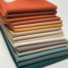 a stack of different colored sheets on top of each other in various sizes and colors