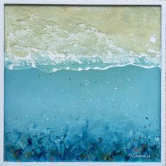 an ocean scene with blue water and white sand, framed in a white wooden frame