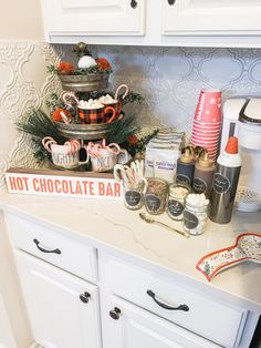 a kitchen counter topped with lots of candy and candies next to a hot chocolate bar