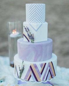 a three tiered cake with lavender flowers on top