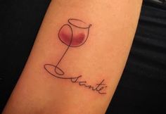 a woman's arm with a wine glass tattoo on it