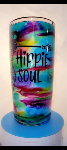 a colorful glass with the words hippie soul on it sitting on top of a blue stool