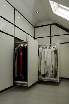 an open closet with clothes hanging on hangers