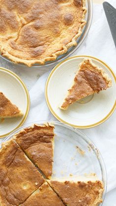 three slices of pie sitting on top of plates next to a knife and spatula