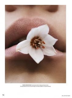 a white flower sticking out of the lip of a woman