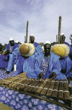 a group of men sitting on top of an instrument