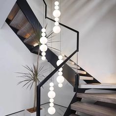 a modern staircase with white balls hanging from it