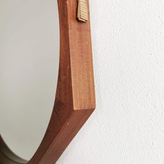 a mirror hanging on the side of a wall with a toothbrush in it's holder